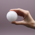 Selenite Sphere - hand shot, purple background