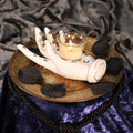 Palmistry Hand Tealight Candle Holder - moody lifestyle shot with lit candle on gold tray with black rose petals
