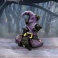 Black cats witch hat figurine styled in moody forest setting