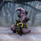Black cats witch hat figurine styled in moody forest setting