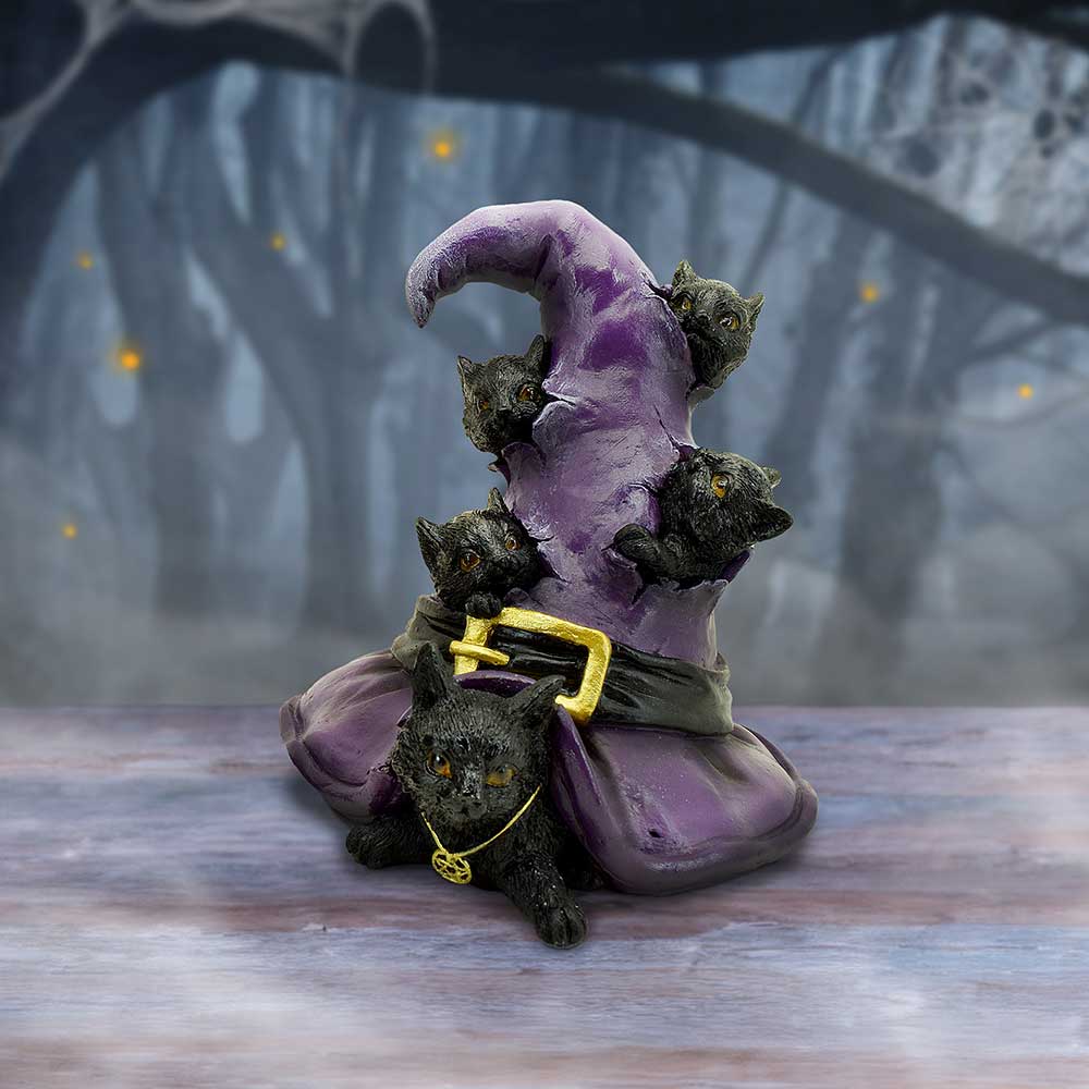 Black cats witch hat figurine styled in moody forest setting
