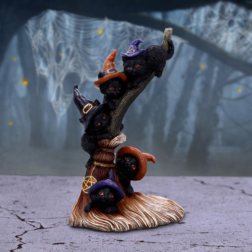 Witch cats broomstick figurine full view on cracked stone surface