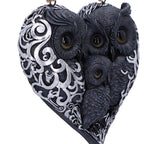 Owl family heart wall hanging displayed on dark tree bark at night